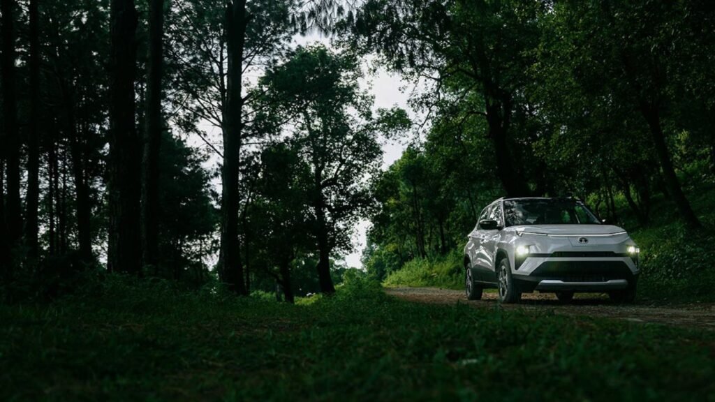 The Tata Punch EV driving through a green forest road, symbolising eco-friendly mobility and quiet electric performance.